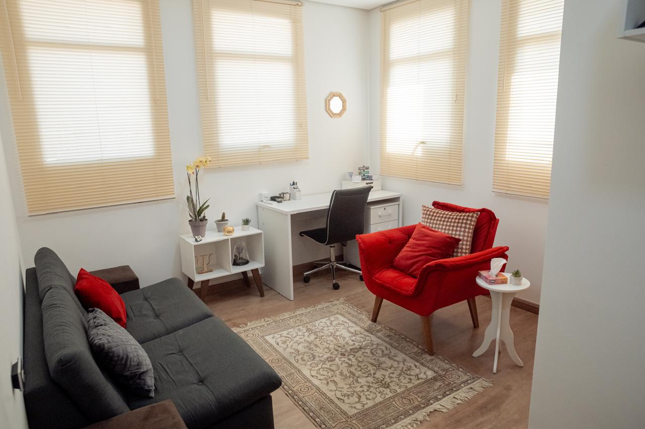 Sala de atendimento da Clínica JF Psicologia, com poltrona, mesa de trabalho e ambiente acolhedor